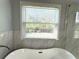 Bathroom detail highlighting a modern tub, marble tile and natural light from the window at 9450 Knollcrest Blvd, Alpharetta, GA 30022