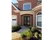 Home entrance featuring double doors, beautiful brickwork and manicured garden bed at 9450 Knollcrest Blvd, Alpharetta, GA 30022