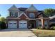 Charming two-story brick home with a well-manicured lawn and attached two-car garage at 9450 Knollcrest Blvd, Alpharetta, GA 30022