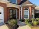 Close up of the front porch with black double doors, brick facade, and manicured landscaping at 9450 Knollcrest Blvd, Alpharetta, GA 30022