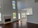 Inviting living room with a fireplace, tall windows, and an open layout to a bar and kitchen area at 9450 Knollcrest Blvd, Alpharetta, GA 30022