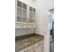 Charming pantry featuring elegant glass cabinets, granite countertops, and seamless access to the kitchen at 9450 Knollcrest Blvd, Alpharetta, GA 30022