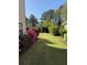 Side yard featuring lush landscaping and a well-maintained lawn with flowering azaleas at 9450 Knollcrest Blvd, Alpharetta, GA 30022