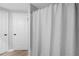 Bright bathroom featuring a shower with a patterned curtain and white paneled doors at 4307 Orchard Park Ct # A, Stone Mountain, GA 30083