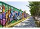 A long graffiti wall running alongside a sidewalk along the Atlanta BeltLine trail at 791 Wylie Se St # 1111, Atlanta, GA 30316