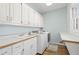 Bright laundry room featuring cabinetry and modern appliances at 1414 Lynchburg Trce, Grayson, GA 30017