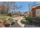 Landscaped backyard with large boulders, mature plantings, and a beautiful brick home at 1414 Lynchburg Trce, Grayson, GA 30017