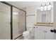 Bathroom with tiled glass shower, granite countertop and white cabinets, illuminated by modern lighting at 1456 Hedgewood Nw Ln, Kennesaw, GA 30152