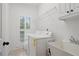 Bright laundry room with white appliances, tiled floor, and natural light coming through the window at 1456 Hedgewood Nw Ln, Kennesaw, GA 30152