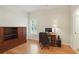 A bright office space with a wooden built-in cabinet and desk complemented by hardwood floors and natural light at 1456 Hedgewood Nw Ln, Kennesaw, GA 30152
