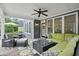 Cozy covered patio features a plush green sectional, ceiling fan, and stylish outdoor furniture at 1456 Hedgewood Nw Ln, Kennesaw, GA 30152
