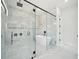 Contemporary bathroom features a luxurious soaking tub, glass shower, marble walls and black hardware for a modern design at 155 Westbrook St, Buford, GA 30518