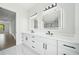 Bright bathroom boasts a double vanity, LED mirrors, modern fixtures, and marble floors, offering a spa-like experience at 155 Westbrook St, Buford, GA 30518