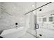 Spa-like bathroom offers a soaking tub, glass shower with marble tile, black hardware and a modern, luxurious feel at 155 Westbrook St, Buford, GA 30518