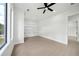 Bright, spacious bedroom with large windows, built-in shelving, and a modern ceiling fan at 155 Westbrook St, Buford, GA 30518