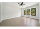 Spacious bedroom with a ceiling fan, recessed lighting, and three windows offering wooded views at 155 Westbrook St, Buford, GA 30518