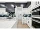 Modern kitchen with sleek white cabinetry, stainless steel appliances, and a hidden walk-in pantry at 155 Westbrook St, Buford, GA 30518