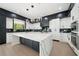 Stunning kitchen features a large island, modern black and white cabinetry, and high-end stainless steel appliances at 155 Westbrook St, Buford, GA 30518