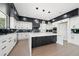 Sleek kitchen design with contrasting black and white cabinets, marble countertops and modern lighting fixtures at 155 Westbrook St, Buford, GA 30518