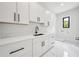 Laundry room with sleek, white cabinetry, marble floors, and a modern black faucet at 155 Westbrook St, Buford, GA 30518
