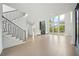 Bright living room featuring a staircase, hardwood floors, a fireplace, and large windows at 155 Westbrook St, Buford, GA 30518
