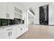 Elegant living space featuring custom cabinets, a wine wrack and a fireplace, seamlessly flowing into the kitchen at 155 Westbrook St, Buford, GA 30518