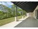 Covered patio with concrete flooring, brick pillars, black trim, and a peaceful backyard view at 155 Westbrook St, Buford, GA 30518