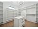 Bright walk-in closet features custom shelving, drawers and a central island, offering ample storage and organization at 155 Westbrook St, Buford, GA 30518