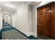 Hallway with blue patterned carpet, decorative lighting, and elegant white trim leading to the unit's wooden door at 28315 Plantation Ne Dr, Atlanta, GA 30324