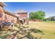 Large backyard with a brick home featuring a doghouse, beautiful trees, an outdoor patio area and well-kept grass at 1135 Azalea Cir, Conyers, GA 30013