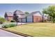 Well-maintained brick home showcasing an attached three-car garage, mature landscaping, and a lush lawn at 1135 Azalea Cir, Conyers, GA 30013