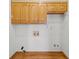 A laundry room with wooden cabinets and wood flooring ready for upgrades at 1135 Azalea Cir, Conyers, GA 30013