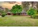 Inviting single-story brick house with lush green lawn and mature trees at sunset at 1311 Maple Street Se, Conyers, GA 30013
