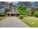 Brick home featuring a spacious driveway, carport, and lush landscaping at 1311 Maple Street Se, Conyers, GA 30013