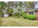 Brick home with a well-maintained lawn, lovely landscaping, and convenient storage shed at 1311 Maple Street Se, Conyers, GA 30013
