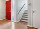 Bright entryway featuring hardwood floors, a vibrant red door, and staircase to the second level at 2005 Variations Ne Dr, Atlanta, GA 30329
