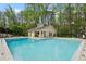 Outdoor swimming pool with clear blue water, adjacent clubhouse, and manicured landscaping at 2005 Variations Ne Dr, Atlanta, GA 30329