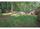 Backyard view shows a large green area surrounded by trees and a wooden fence at 260 Sterling Dr, Powder Springs, GA 30127