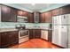 A lovely kitchen featuring stainless steel appliances, granite counters and dark brown cabinets at 260 Sterling Dr, Powder Springs, GA 30127