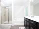 Bright bathroom featuring a dark vanity, glass shower, and bathtub at 3080 W Jackson Way, Austell, GA 30106