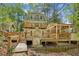 Multi-level deck with covered area perfect for outdoor entertaining, surrounded by lush greenery at 3125 Lakeside Dr, Cumming, GA 30041
