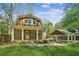 Charming home with carport; showcasing a well-manicured lawn, lush trees, and a cozy porch at 3125 Lakeside Dr, Cumming, GA 30041