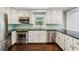 Bright kitchen features stainless appliances, white cabinetry, and green backsplash at 3125 Lakeside Dr, Cumming, GA 30041