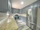 Modern kitchen featuring gray cabinets, granite countertops, stainless steel appliances, and stylish subway tile backsplash at 1206 Park Place Dr, Jonesboro, GA 30236