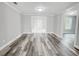 Bright, open-concept living room featuring gray walls, white trim, and modern wood-look flooring at 1206 Park Place Dr, Jonesboro, GA 30236