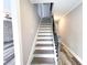Elegant staircase with hardwood treads, white risers, and a decorative metal handrail at 1206 Park Place Dr, Jonesboro, GA 30236
