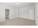 This bedroom features neutral carpet and paint, and a door to the bathroom, providing a serene and functional space at 3265 Lions Ruby Ln, Atlanta, GA 30349