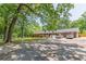 Charming brick home surrounded by lush greenery and mature trees with spacious parking at 5150 Scofield Rd, College Park, GA 30349