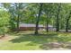 Brick home nestled among mature trees, with a well-maintained green lawn at 5150 Scofield Rd, College Park, GA 30349