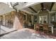 Covered back porch featuring brick accents, outdoor seating, and wooded views at 5655 Mccoy Rd Nw, Acworth, GA 30101